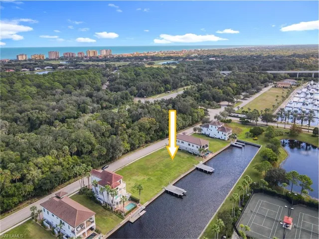Waterfront lot featuring a private boat dock, green lawn, established trees, and canal access