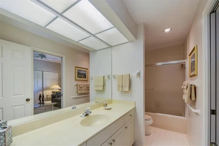 Full bathroom featuring combined bath / shower with glass door, vanity, toilet, and tile patterned floors