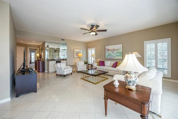 Living room with ceiling fan and light tile patterned flooring