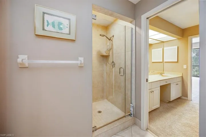 Bathroom featuring tile patterned flooring, an enclosed shower, and vanity