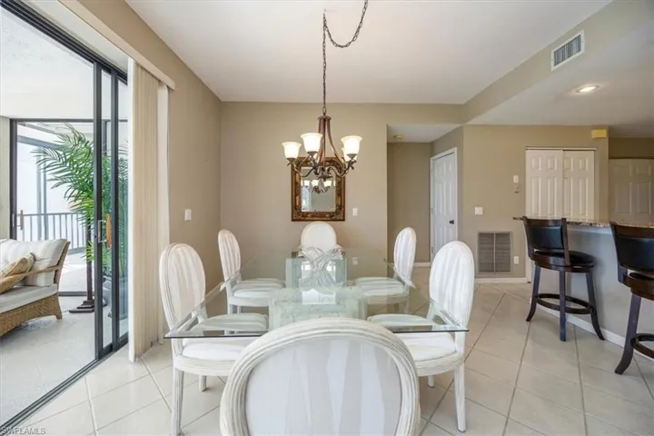 Dining area featuring a wealth of natural light, a notable chandelier, and light tile patterned flooring