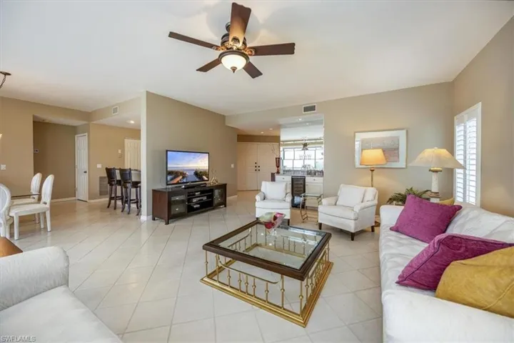 Living room featuring light tile patterned floors and ceiling fan