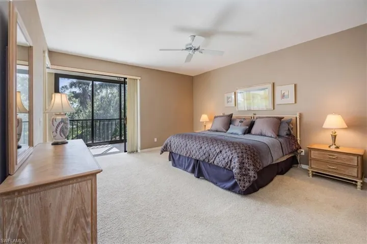 Carpeted bedroom with ceiling fan and access to outside