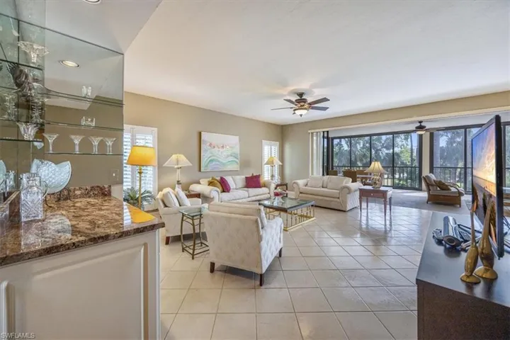 Tiled living room with plenty of natural light and ceiling fan