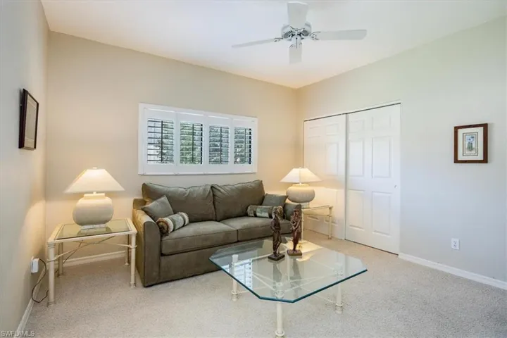 Living room featuring ceiling fan and light carpet