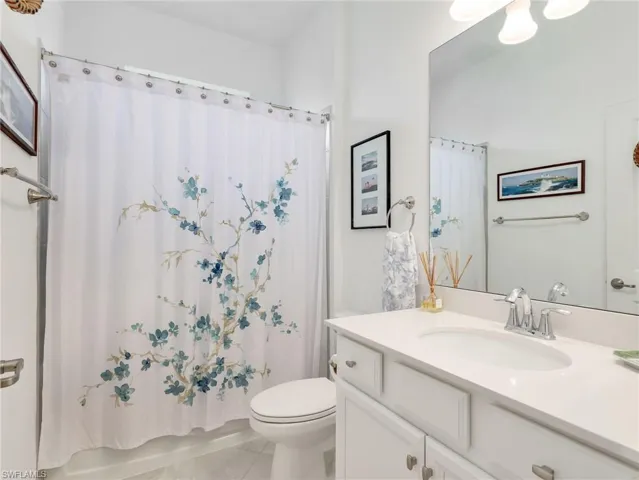 Bathroom featuring a white vanity with an integrated sink, polished chrome faucet, and a large wall-mounted mirror