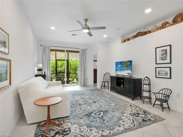 Bright living area featuring high ceilings, recessed lighting, and tile flooring