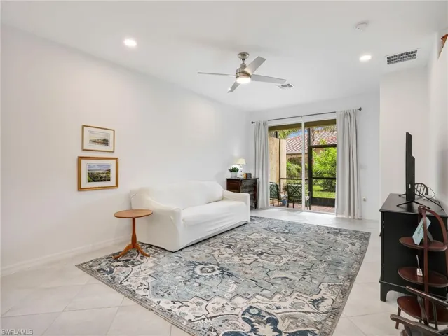Spacious interior room featuring tile flooring, a recessed lighting array, and a ceiling fan with integrated lighting