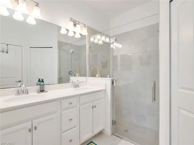 Spacious bathroom featuring a dual vanity with white cabinetry and a light-colored countertop