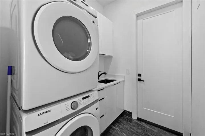 Laundry room with estacked washer and dryer and cabinet space
