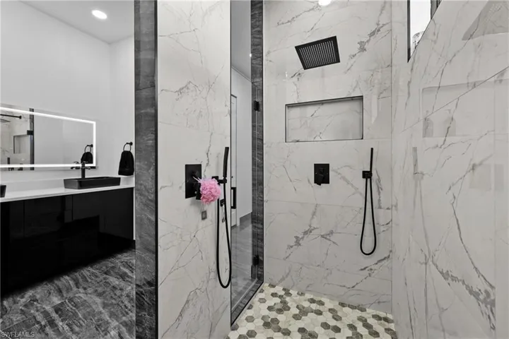 Full bathroom with a marble finish shower and vanity