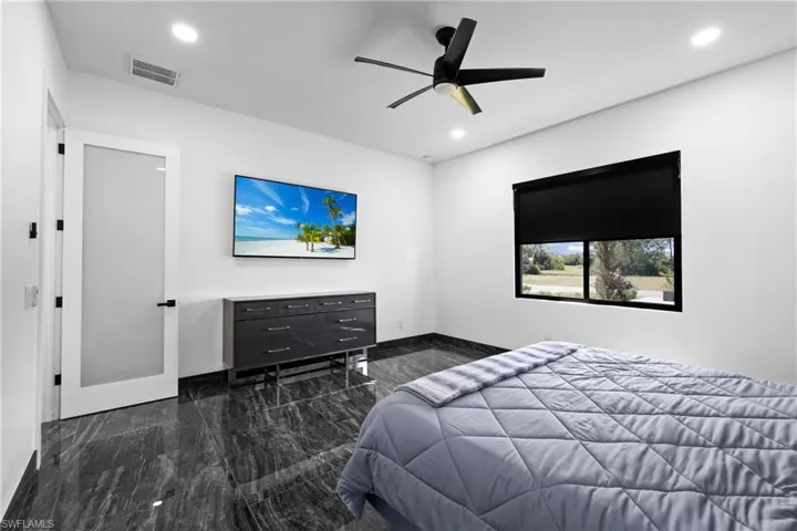 Bedroom featuring marble tiled flooring, recessed lighting, baseboards, and a ceiling fan