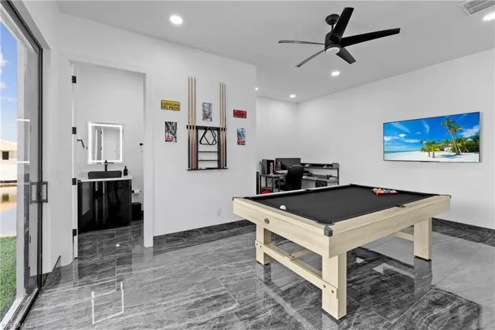 Recreation room with marble tiled floors, ceiling fan, billiards, recessed lighting, and a desk