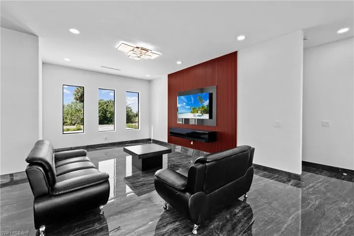 Cinema featuring recessed lighting, marble tiled flooring, and baseboards