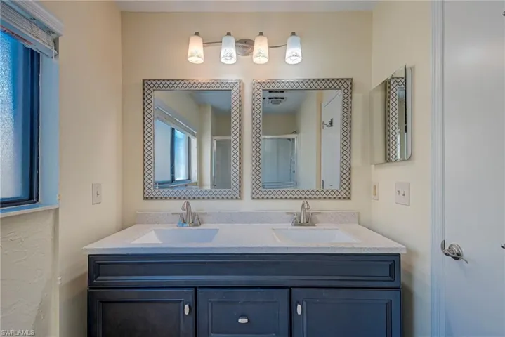 Bathroom featuring double vanity and a stall shower