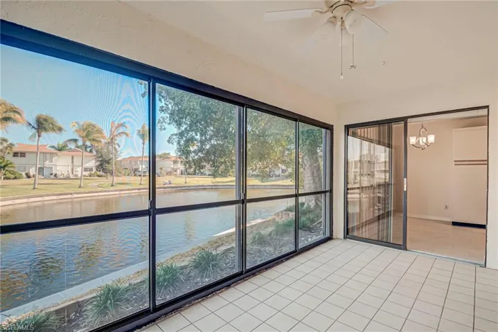 Unfurnished sunroom featuring a water view and a chandelier