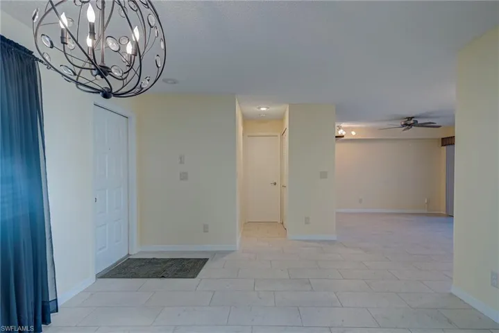 Empty room with a chandelier and ceiling fan