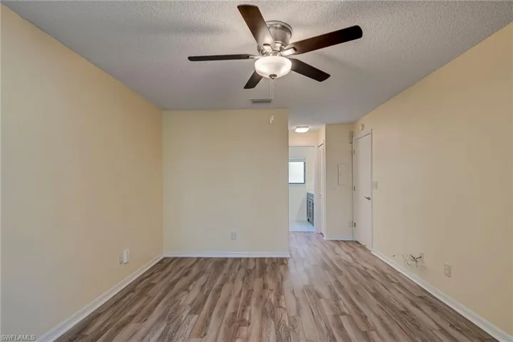 Spare room with light wood finished floors, a textured ceiling, and ceiling fan