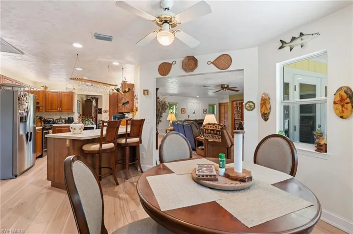 Dining area featuring light wood finished floors, a ceiling fan, and baseboards