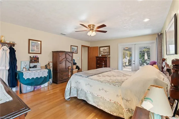 Bedroom featuring access to exterior, multiple windows, french doors, and light wood-style floors