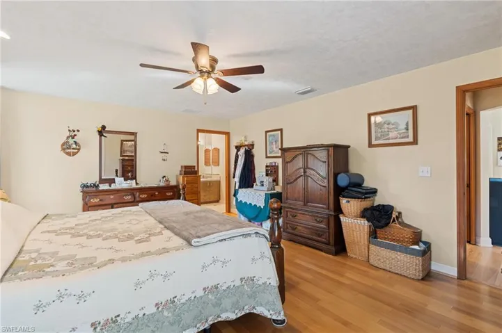 Bedroom featuring a ceiling fan, visible vents, access to exterior, french doors, and light wood-style floors