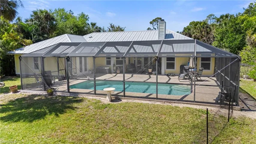 Outdoor pool featuring a lanai and a yard