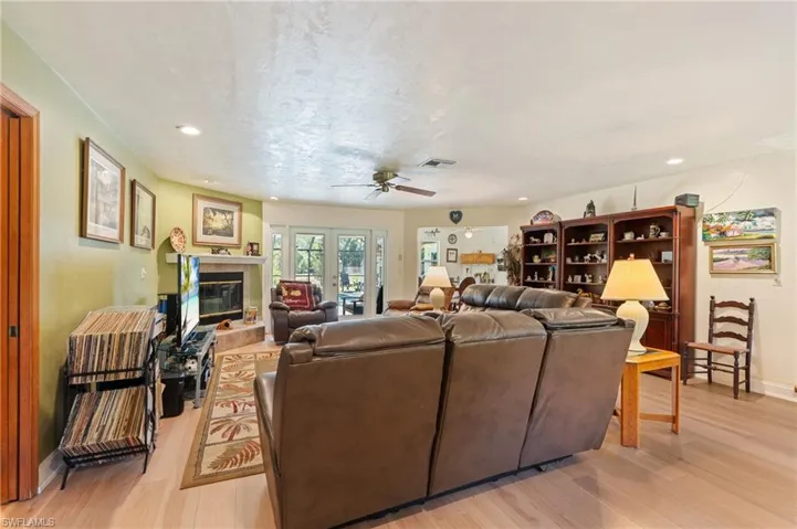 Living room featuring light wood finished floors, recessed lighting, a textured ceiling, and ceiling fan