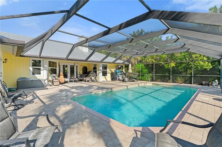 Outdoor pool with french doors, a patio, and glass enclosure