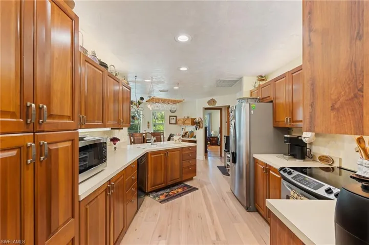 Living area featuring a ceiling fan, baseboards, visible vents, light wood-style floors, and a tiled fireplace