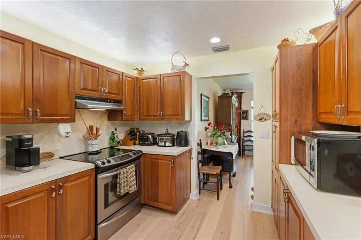 Kitchen featuring open floor plan, light countertops, a kitchen bar, a peninsula, and a sink