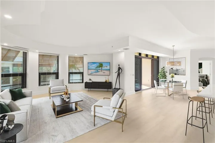 Living area featuring light wood-type flooring, recessed lighting, baseboards, arched walkways, and ornamental molding