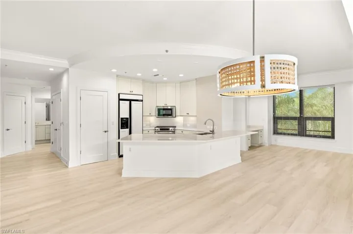 Kitchen featuring light countertops, a sink, stainless steel appliances, and light wood finished floors