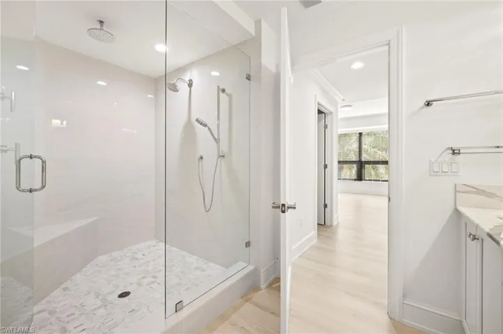 Bathroom with a shower stall, baseboards, wood finished floors, recessed lighting, and vanity