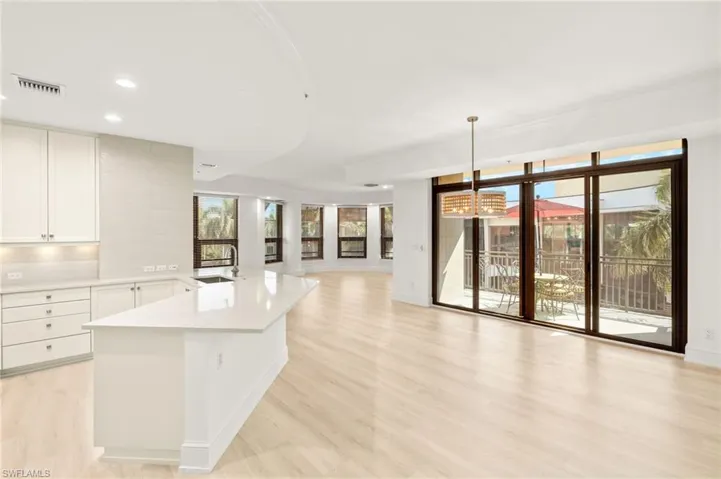 Kitchen with an inviting chandelier, light countertops, a healthy amount of sunlight, and light wood-style flooring