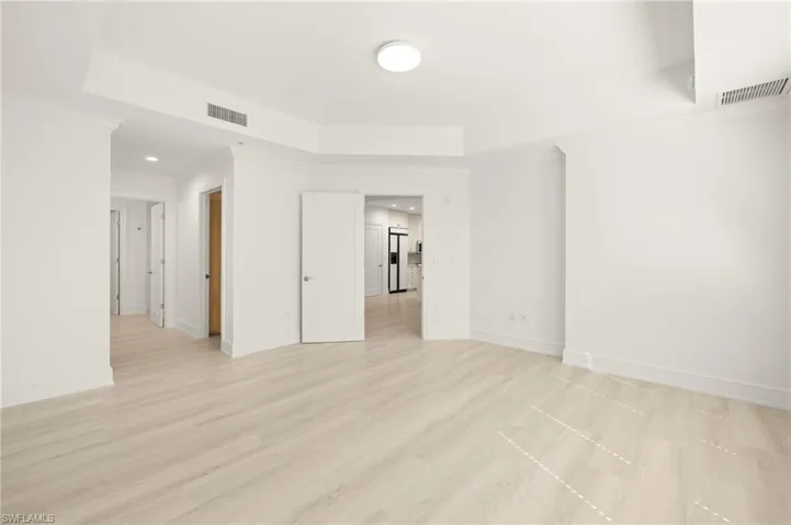 Spare room featuring a tray ceiling, baseboards, and visible vents