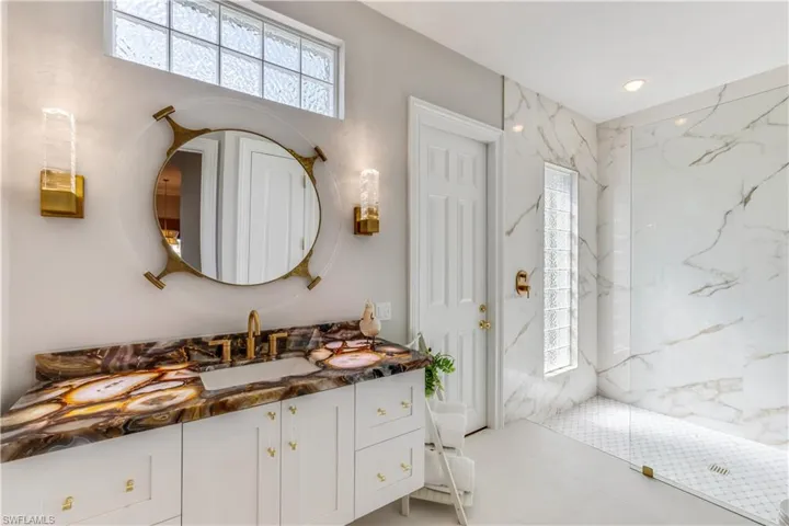 Full bathroom with vanity and a marble finish shower