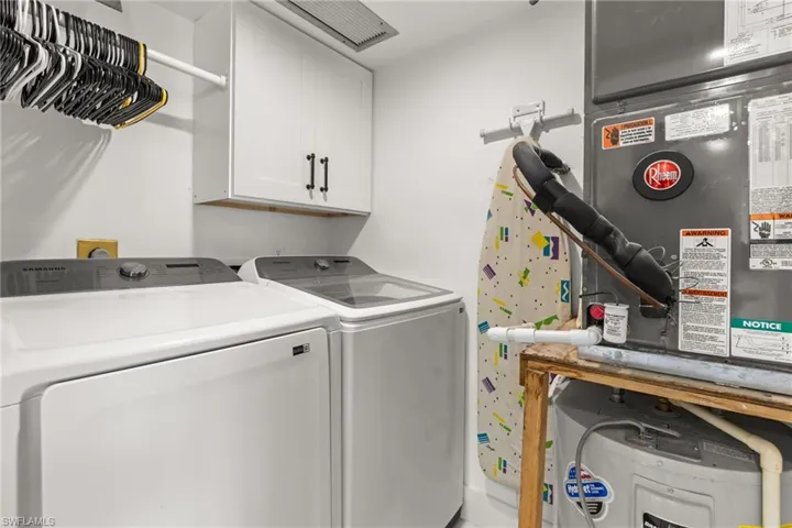 Laundry area featuring independent washer and dryer and cabinets
