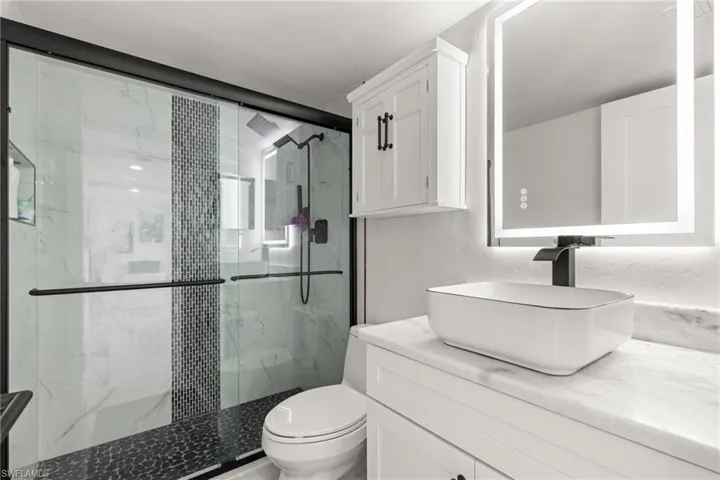 Bathroom with vanity, toilet, and walk in shower