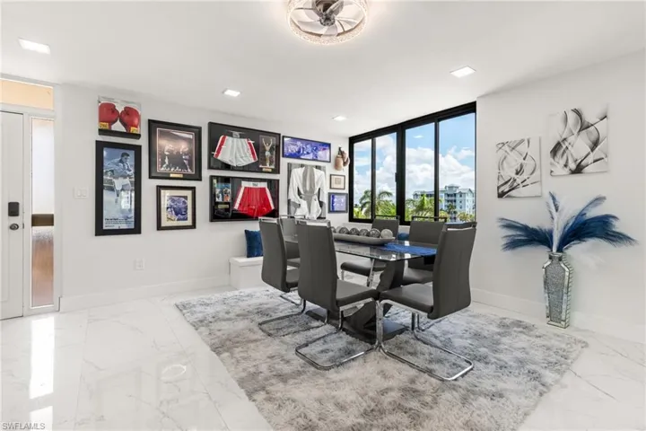 Dining room featuring ceiling fan and a wall of windows
