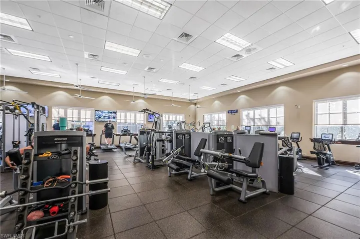 Pelican Marsh Exercise room featuring plenty of natural light and a drop ceiling