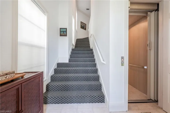 Entry Staircase with carpeted flooring and elevator