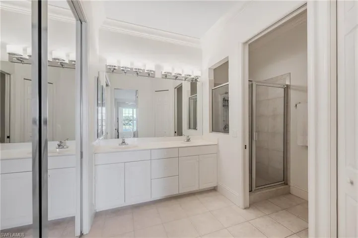 Master Bathroom featuring vanity, tile patterned floors, a shower with shower door, and ornamental Crown molding