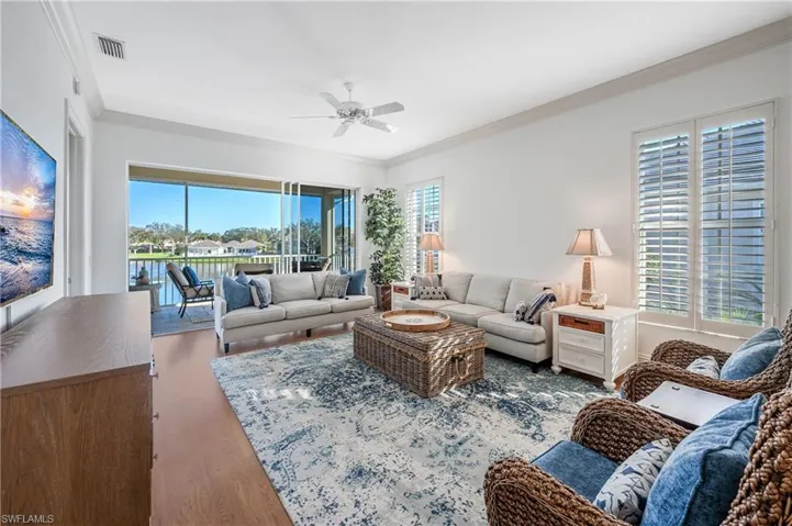 Living room with ceiling fan, a healthy amount of sunlight, ornamental molding, and Laminate floors
