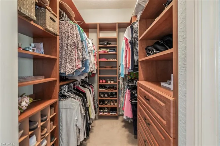 Spacious Master Bedroom custom closet featuring light colored carpet