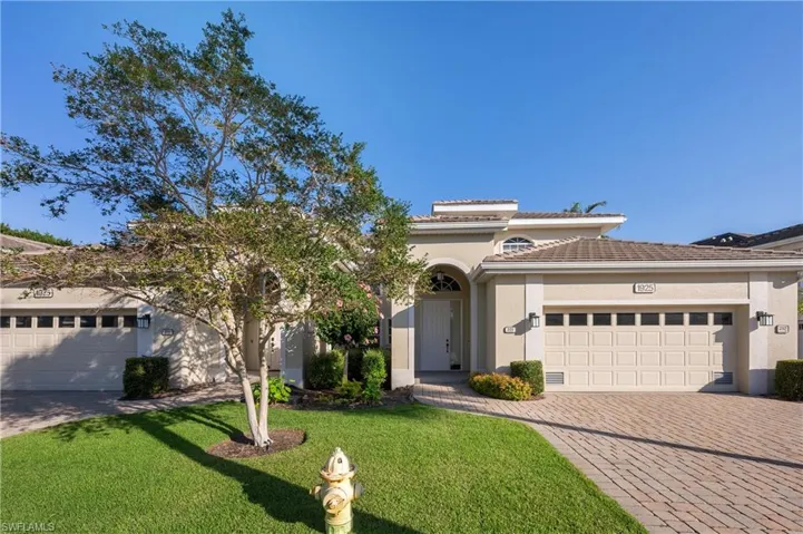 View of front of home with a garage and a front lawn
