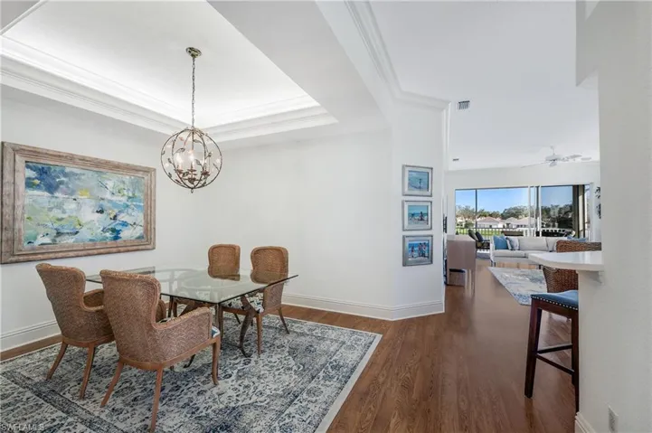 Dining area featuring a tray ceiling, ornamental molding, and Laminate floors
