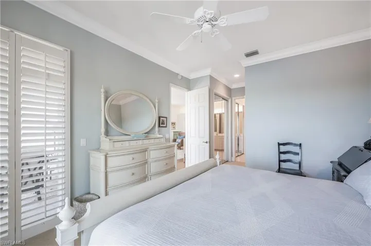 Master Bedroom with plantation shutters, crown molding, ceiling fan, and ensuite bathroom