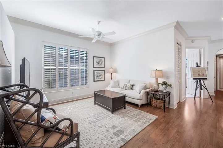 Family room featuring Crown molding, dark laminate flooring, and ceiling fan