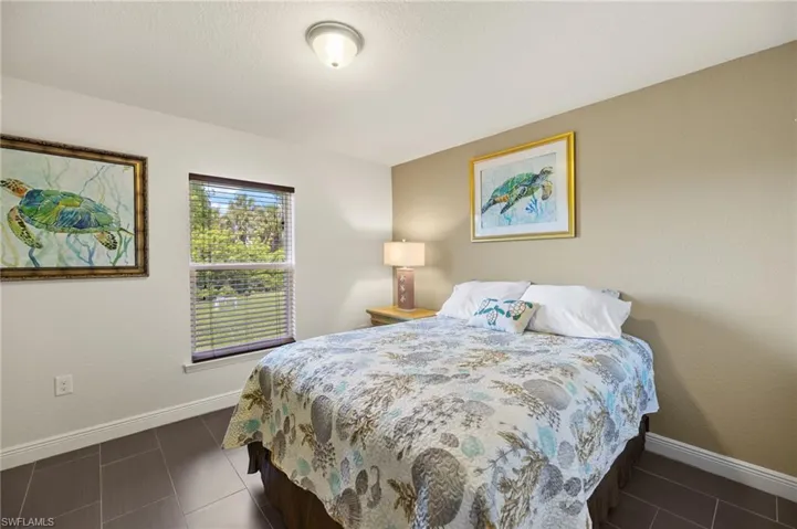 Bedroom featuring baseboards and dark tile patterned flooring