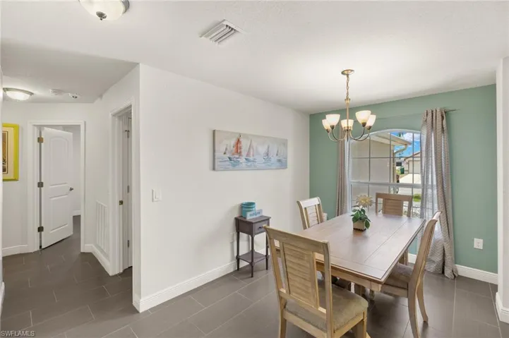 Dining area featuring a chandelier and baseboards